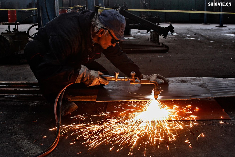 在工業(yè)生產(chǎn)中,鋼板切割是一項(xiàng)至關(guān)重要的工藝,廣泛應(yīng)用于機(jī)械制造、建筑、橋梁建設(shè)等多個(gè)領(lǐng)域。為了滿足不同項(xiàng)目的需求,鋼板切割采用了多種加工方式。本文將詳細(xì)介紹鋼板切割中常見的幾種加工方式,包括火焰切割、激光切割、等離子切割、水刀切割以及機(jī)械切割等。 一、火焰切割 火焰切割是利用氧氣和乙炔的燃燒產(chǎn)生的高溫火焰來切割鋼板的一種加工方式。在切割過程中,火焰將鋼板局部加熱至熔化狀態(tài),同時(shí)氧氣流將熔化的金屬吹走,形成切口。火焰切割設(shè)備相對簡單,成本低廉,適用于切割厚度較大的鋼板。然而,由于切割過程中產(chǎn)生的熱影響區(qū)較大,易導(dǎo)致鋼板變形和材質(zhì)變化,因此精度和表面質(zhì)量相對較低。 二、激光切割 激光切割是利用高功率密度的激光束照射鋼板表面,使鋼板迅速熔化、汽化或達(dá)到點(diǎn)燃點(diǎn),同時(shí)以高速氣流將熔化或燃燒的金屬吹走,形成切口。激光切割具有切割速度快、精度高、熱影響區(qū)小等優(yōu)點(diǎn),特別適用于切割薄板和中厚板。此外,激光切割還能實(shí)現(xiàn)自動化和智能化生產(chǎn),提高生產(chǎn)效率。 三、等離子切割 等離子切割是利用高溫、高速度的等離子氣體流對鋼板進(jìn)行切割的一種加工方式。在切割過程中,等離子氣體流將鋼板局部熔化,并通過氣流將熔化的金屬吹走。等離子切割適用于切割中厚板和厚板,具有切割速度快、熱影響區(qū)小、切口平整等優(yōu)點(diǎn)。然而,等離子切割設(shè)備的成本較高,維護(hù)也相對復(fù)雜。 四、水刀切割 水刀切割是利用高壓水流對鋼板進(jìn)行切割的一種加工方式。在切割過程中,高壓水流將鋼板局部沖蝕,形成切口。水刀切割具有切割精度高、表面質(zhì)量好、無熱影響區(qū)等優(yōu)點(diǎn),特別適用于切割薄板和對表面質(zhì)量要求較高的項(xiàng)目。此外,水刀切割還能實(shí)現(xiàn)綠色生產(chǎn),減少環(huán)境污染。 五、機(jī)械切割 機(jī)械切割是利用切割機(jī)械對鋼板進(jìn)行切割的一種加工方式,如鋸床切割、銑床切割等。機(jī)械切割適用于切割各種厚度和材質(zhì)的鋼板,具有切割精度高、切口平整、適應(yīng)性強(qiáng)等優(yōu)點(diǎn)。然而,機(jī)械切割的速度相對較慢,生產(chǎn)效率較低,且對于較厚的鋼板,切割難度較大。 在選擇鋼板切割加工方式時(shí),需要根據(jù)項(xiàng)目的具體需求、鋼板的厚度和材質(zhì)、生產(chǎn)效率和成本等因素進(jìn)行綜合考慮。對于要求高精度、高表面質(zhì)量的切割項(xiàng)目,激光切割和水刀切割是較為理想的選擇;對于切割厚度較大、對表面質(zhì)量要求不高的項(xiàng)目,火焰切割和等離子切割則更具優(yōu)勢;而對于需要靈活應(yīng)對各種切割需求的場景,機(jī)械切割則是一種可靠的選擇。 總之,隨著科技的不斷進(jìn)步和工業(yè)生產(chǎn)的不斷發(fā)展,鋼板切割加工方式也在不斷創(chuàng)新和完善。了解各種加工方式的優(yōu)缺點(diǎn),并根據(jù)實(shí)際需求選擇合適的加工方式,對于提高鋼板切割的質(zhì)量和效率具有重要意義。 在工業(yè)生產(chǎn)中,鋼板切割是一項(xiàng)至關(guān)重要的工藝,廣泛應(yīng)用于機(jī)械制造、建筑、橋梁建設(shè)等多個(gè)領(lǐng)域。為了滿足不同項(xiàng)目的需求,鋼板切割采用了多種加工方式。本文將詳細(xì)介紹鋼板切割中常見的幾種加工方式,包括火焰切割、激光切割、等離子切割、水刀切割以及機(jī)械切割等。 一、火焰切割 火焰切割是利用氧氣和乙炔的燃燒產(chǎn)生的高溫火焰來切割鋼板的一種加工方式。在切割過程中,火焰將鋼板局部加熱至熔化狀態(tài),同時(shí)氧氣流將熔化的金屬吹走,形成切口。火焰切割設(shè)備相對簡單,成本低廉,適用于切割厚度較大的鋼板。然而,由于切割過程中產(chǎn)生的熱影響區(qū)較大,易導(dǎo)致鋼板變形和材質(zhì)變化,因此精度和表面質(zhì)量相對較低。 二、激光切割 激光切割是利用高功率密度的激光束照射鋼板表面,使鋼板迅速熔化、汽化或達(dá)到點(diǎn)燃點(diǎn),同時(shí)以高速氣流將熔化或燃燒的金屬吹走,形成切口。激光切割具有切割速度快、精度高、熱影響區(qū)小等優(yōu)點(diǎn),特別適用于切割薄板和中厚板。此外,激光切割還能實(shí)現(xiàn)自動化和智能化生產(chǎn),提高生產(chǎn)效率。 三、等離子切割 等離子切割是利用高溫、高速度的等離子氣體流對鋼板進(jìn)行切割的一種加工方式。在切割過程中,等離子氣體流將鋼板局部熔化,并通過氣流將熔化的金屬吹走。等離子切割適用于切割中厚板和厚板,具有切割速度快、熱影響區(qū)小、切口平整等優(yōu)點(diǎn)。然而,等離子切割設(shè)備的成本較高,維護(hù)也相對復(fù)雜。 四、水刀切割 水刀切割是利用高壓水流對鋼板進(jìn)行切割的一種加工方式。在切割過程中,高壓水流將鋼板局部沖蝕,形成切口。水刀切割具有切割精度高、表面質(zhì)量好、無熱影響區(qū)等優(yōu)點(diǎn),特別適用于切割薄板和對表面質(zhì)量要求較高的項(xiàng)目。此外,水刀切割還能實(shí)現(xiàn)綠色生產(chǎn),減少環(huán)境污染。 五、機(jī)械切割 機(jī)械切割是利用切割機(jī)械對鋼板進(jìn)行切割的一種加工方式,如鋸床切割、銑床切割等。機(jī)械切割適用于切割各種厚度和材質(zhì)的鋼板,具有切割精度高、切口平整、適應(yīng)性強(qiáng)等優(yōu)點(diǎn)。然而,機(jī)械切割的速度相對較慢,生產(chǎn)效率較低,且對于較厚的鋼板,切割難度較大。 在選擇鋼板切割加工方式時(shí),需要根據(jù)項(xiàng)目的具體需求、鋼板的厚度和材質(zhì)、生產(chǎn)效率和成本等因素進(jìn)行綜合考慮。對于要求高精度、高表面質(zhì)量的切割項(xiàng)目,激光切割和水刀切割是較為理想的選擇;對于切割厚度較大、對表面質(zhì)量要求不高的項(xiàng)目,火焰切割和等離子切割則更具優(yōu)勢;而對于需要靈活應(yīng)對各種切割需求的場景,機(jī)械切割則是一種可靠的選擇。 總之,隨著科技的不斷進(jìn)步和工業(yè)生產(chǎn)的不斷發(fā)展,鋼板切割加工方式也在不斷創(chuàng)新和完善。了解各種加工方式的優(yōu)缺點(diǎn),并根據(jù)實(shí)際需求選擇合適的加工方式,對于提高鋼板切割的質(zhì)量和效率具有重要意義。